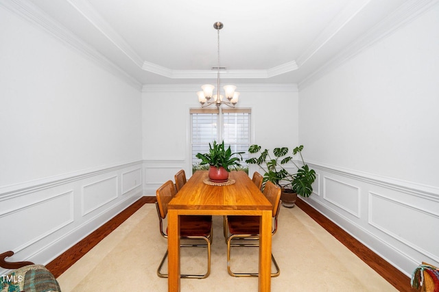 104 Homegate Cir, Apex, NC 27502 - dining room with a chandelier, wood finished floors, crown molding, a decorative wall, and wainscoting
