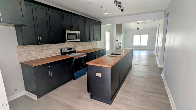 109 N Dunn St, Angier, NC 27501 - kitchen with electric range oven, wooden counters, stainless steel microwave, and dark cabinets