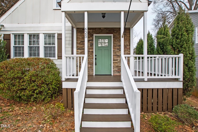 625 New Rd, Raleigh, NC 27608 - property entrance with stone siding, board and batten siding, and covered porch