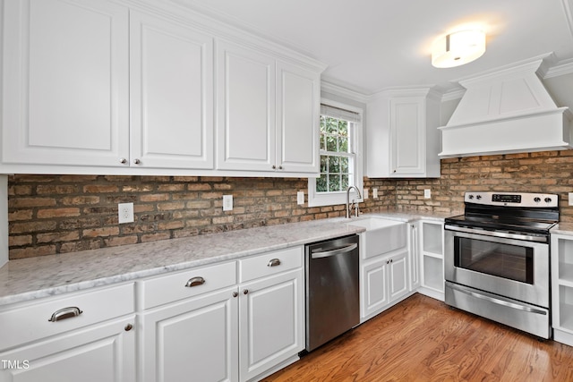 625 New Rd, Raleigh, NC 27608 - kitchen featuring stainless steel appliances, premium range hood, decorative backsplash, white cabinets, and light wood finished floors