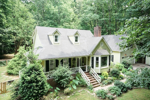 7216 Rabbit Run, Wake Forest, NC 27587 - cape cod house with a chimney, a porch, stairway, an attached garage, and a view of trees
