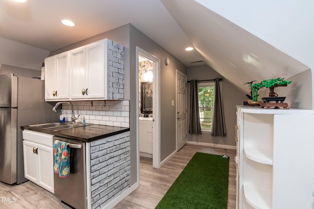 7216 Rabbit Run, Wake Forest, NC 27587 - kitchen with stainless steel appliances, dark countertops, white cabinetry, backsplash, and light wood-style flooring