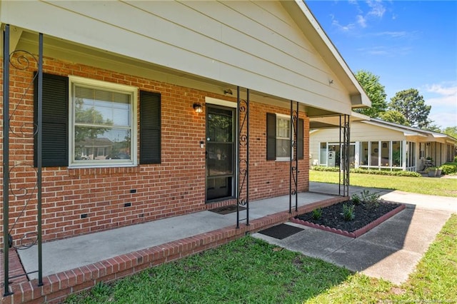 3649 Marcliff Rd, Hope Mills, NC 28348 - view of exterior entry featuring a yard, a porch, and brick siding
