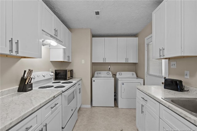 3649 Marcliff Rd, Hope Mills, NC 28348 - kitchen with white range with electric cooktop, washing machine and dryer, stainless steel microwave, under cabinet range hood, and white cabinetry