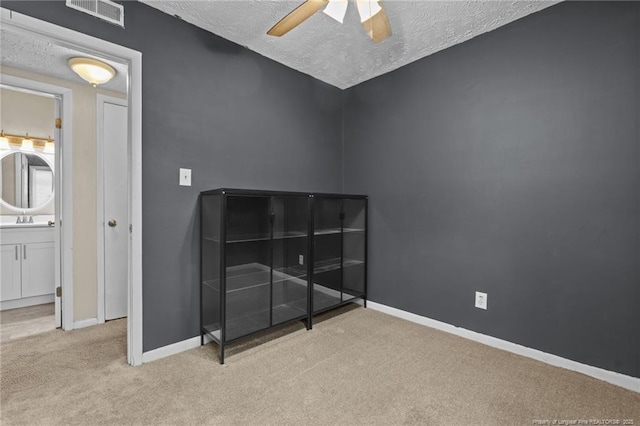 3649 Marcliff Rd, Hope Mills, NC 28348 - unfurnished bedroom with a textured ceiling, carpet floors, ceiling fan, and connected bathroom