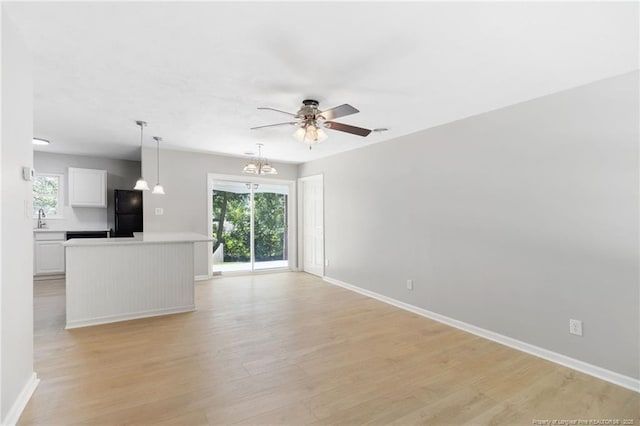 1809 Wendover Dr, Fayetteville, NC 28304 - unfurnished living room featuring a ceiling fan, light wood-type flooring, and a chandelier