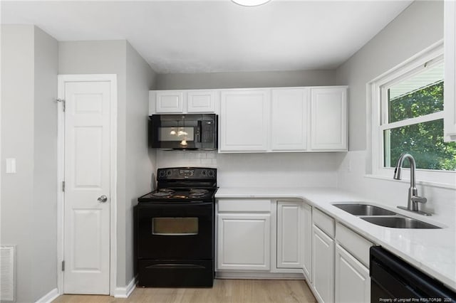 1809 Wendover Dr, Fayetteville, NC 28304 - kitchen featuring black appliances, light wood-type flooring, white cabinetry, and tasteful backsplash
