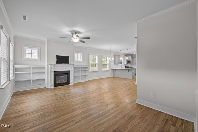 1819 Nixon St, Durham, NC 27707 - unfurnished living room featuring ornamental molding, a ceiling fan, light wood-type flooring, and a glass covered fireplace