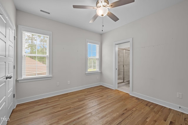 1819 Nixon St, Durham, NC 27707 - unfurnished bedroom featuring multiple windows, light wood-style flooring, ensuite bathroom, and ceiling fan