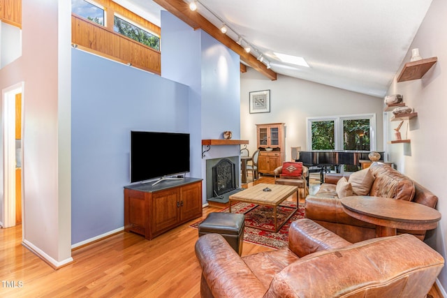 28 Benchmark, Pittsboro, NC 27312 - living room featuring light wood finished floors, a fireplace, high vaulted ceiling, beam ceiling, and a skylight