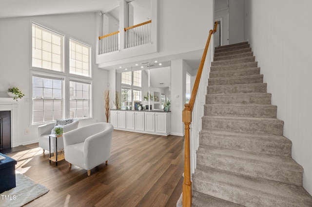 1308 Snyder St, Durham, NC 27713 - stairs with wood finished floors, high vaulted ceiling, and a fireplace with raised hearth