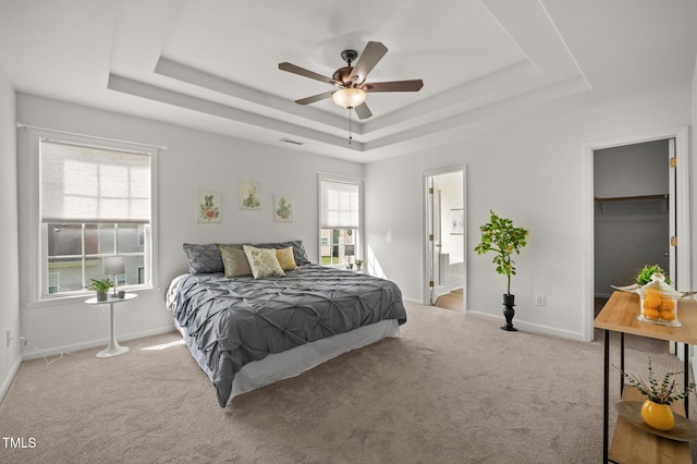 1308 Snyder St, Durham, NC 27713 - carpeted bedroom featuring a raised ceiling, a spacious closet, a ceiling fan, and ensuite bathroom