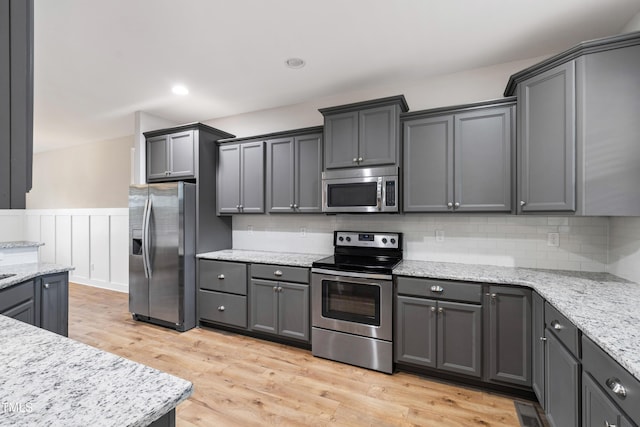 24 Windchime Ct, Clayton, NC 27527 - kitchen with stainless steel appliances, light wood-style flooring, a wainscoted wall, backsplash, and gray cabinets
