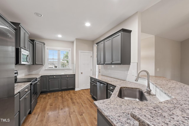 24 Windchime Ct, Clayton, NC 27527 - kitchen with stainless steel appliances, light wood-type flooring, light stone counters, tasteful backsplash, and recessed lighting