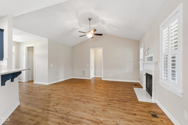 24 Windchime Ct, Clayton, NC 27527 - unfurnished living room with a premium fireplace, a ceiling fan, light wood-style flooring, and lofted ceiling