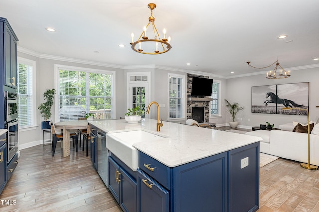 119 Florentino Ct, Clayton, NC 27527 - kitchen with a chandelier, blue cabinetry, light wood-type flooring, a fireplace, and recessed lighting