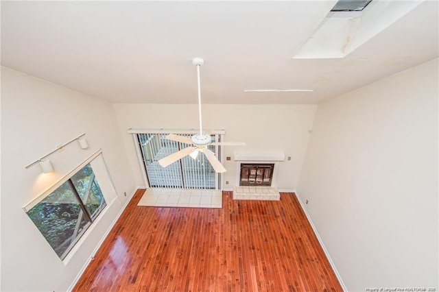 400 Cypress Trace Dr, Fayetteville, NC 28314 - unfurnished living room with wood finished floors, ceiling fan, and a fireplace with raised hearth