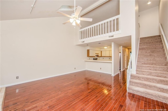 400 Cypress Trace Dr, Fayetteville, NC 28314 - unfurnished living room with wood finished floors, a ceiling fan, stairway, a towering ceiling, and track lighting