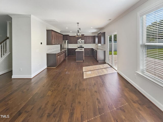1092 Adams Point Dr, Garner, NC 27529 - kitchen with stainless steel appliances, dark brown cabinetry, ornamental molding, plenty of natural light, and a center island