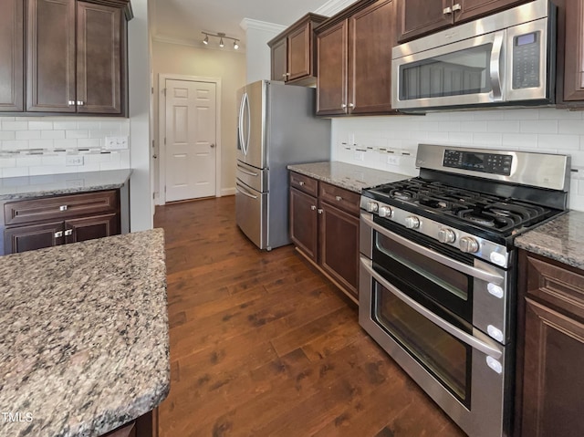 1092 Adams Point Dr, Garner, NC 27529 - kitchen featuring appliances with stainless steel finishes, light stone counters, dark wood finished floors, decorative backsplash, and dark brown cabinetry