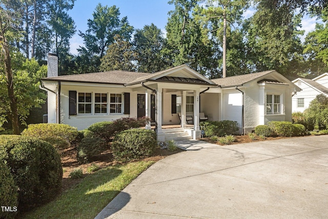 227 W Drewry Ln, Raleigh, NC 27609 - view of front of home featuring brick siding, covered porch, a chimney, and a shingled roof
