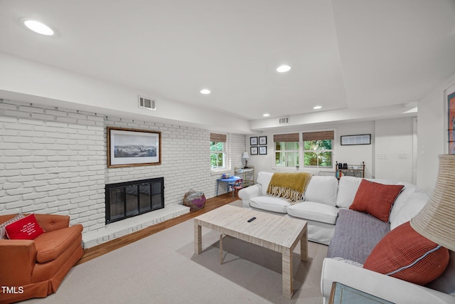 227 W Drewry Ln, Raleigh, NC 27609 - living room featuring a brick fireplace, recessed lighting, brick wall, and wood finished floors