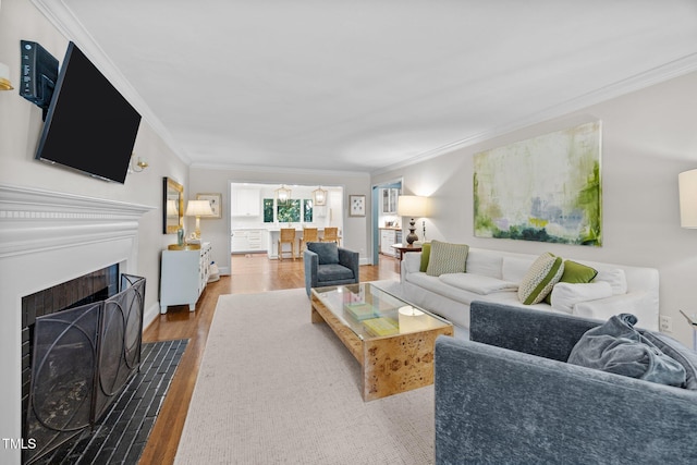 227 W Drewry Ln, Raleigh, NC 27609 - living room featuring crown molding, wood finished floors, and a fireplace with flush hearth