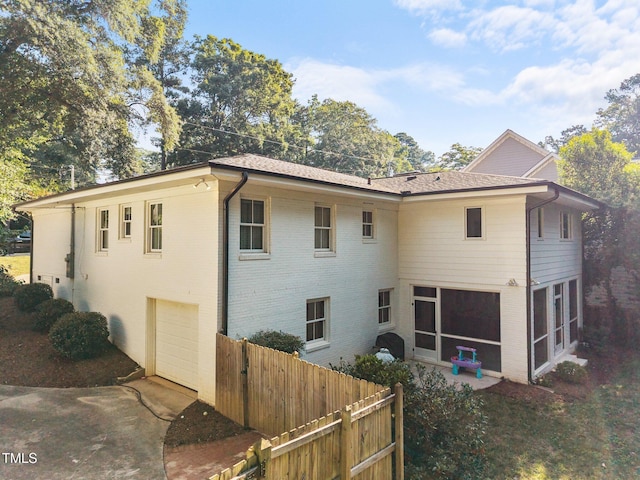 227 W Drewry Ln, Raleigh, NC 27609 - rear view of property with a garage, a sunroom, and brick siding
