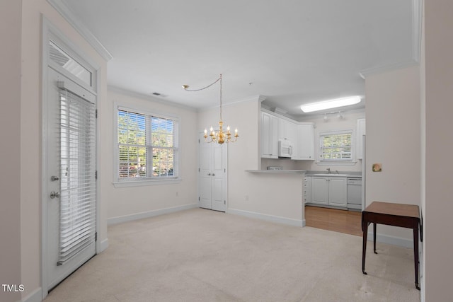 108-203 Northbrook Dr Unit 203, Raleigh, NC 27609 - kitchen featuring white appliances, a chandelier, light colored carpet, white cabinets, and light countertops