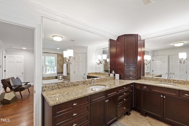 2707 Anderson Dr, Raleigh, NC 27608 - bathroom with crown molding, double vanity, a tub to relax in, wood finished floors, and recessed lighting