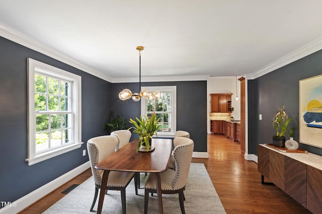 2707 Anderson Dr, Raleigh, NC 27608 - dining space with ornamental molding, a chandelier, and dark wood finished floors
