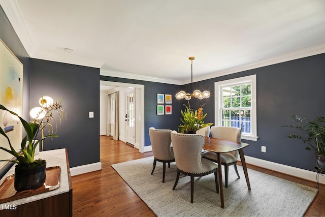 2707 Anderson Dr, Raleigh, NC 27608 - dining area featuring wood finished floors, a chandelier, and crown molding