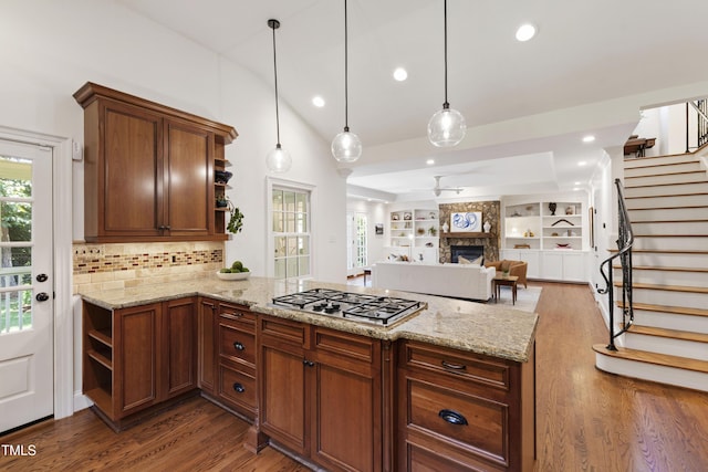 2707 Anderson Dr, Raleigh, NC 27608 - kitchen with open shelves, stainless steel gas cooktop, dark wood-style flooring, a peninsula, and tasteful backsplash