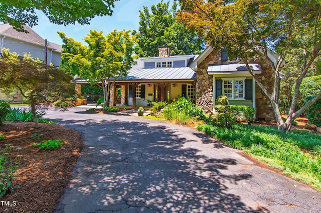 2707 Anderson Dr, Raleigh, NC 27608 - view of front of house featuring a porch, stone siding, a chimney, a standing seam roof, and asphalt driveway