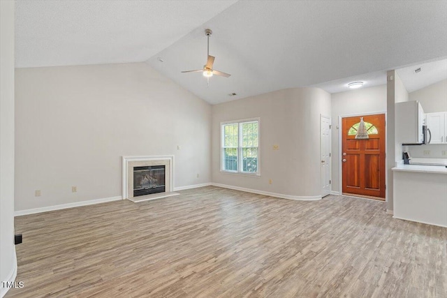 108 Ellsworth Pl, Cary, NC 27511 - unfurnished living room with ceiling fan, light wood-style floors, a glass covered fireplace, and high vaulted ceiling