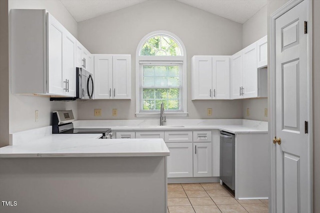 108 Ellsworth Pl, Cary, NC 27511 - kitchen with stainless steel appliances, light countertops, a peninsula, white cabinetry, and light tile patterned flooring