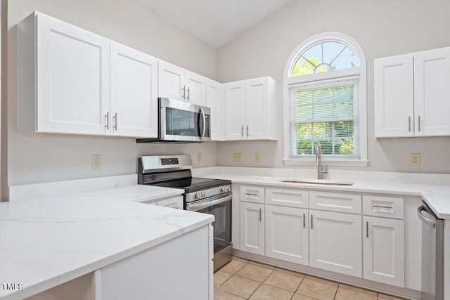 108 Ellsworth Pl, Cary, NC 27511 - kitchen with appliances with stainless steel finishes, white cabinetry, light stone countertops, and plenty of natural light