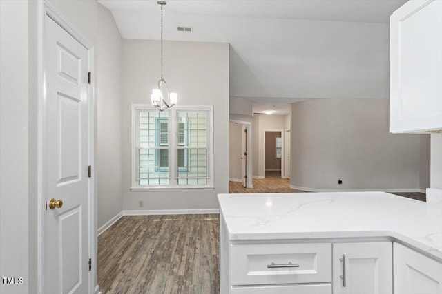 108 Ellsworth Pl, Cary, NC 27511 - kitchen featuring white cabinets, wood finished floors, a peninsula, decorative light fixtures, and light stone counters