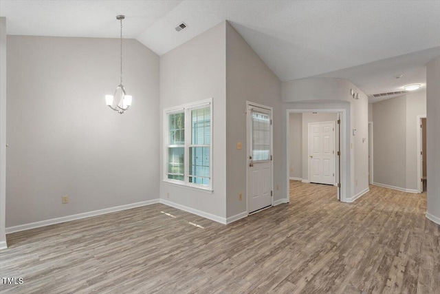 108 Ellsworth Pl, Cary, NC 27511 - empty room with light wood finished floors, a chandelier, and high vaulted ceiling