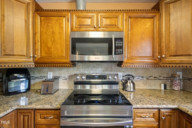 1401 Burchcrest Dr, Garner, NC 27529 - kitchen featuring stainless steel appliances, brown cabinets, decorative backsplash, and light stone counters