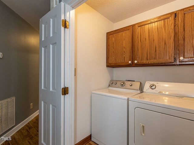 6020 Wildorlyn Cir, Raleigh, NC 27603 - laundry area featuring cabinet space, washer and clothes dryer, and wood finished floors