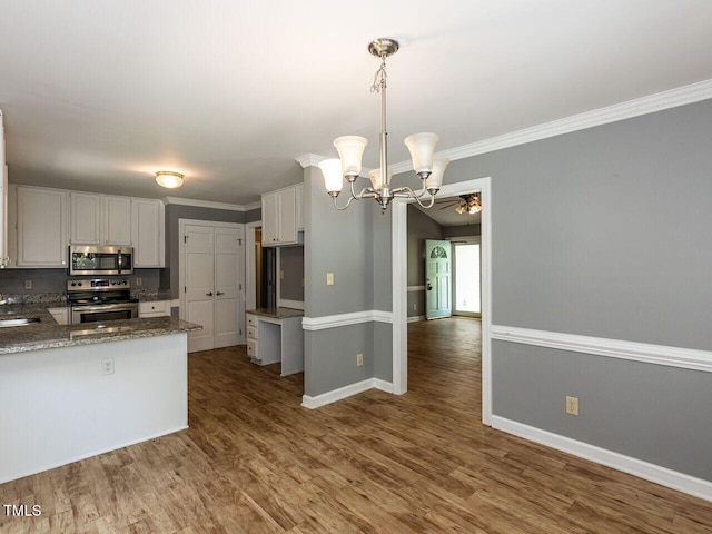 6020 Wildorlyn Cir, Raleigh, NC 27603 - kitchen featuring stainless steel appliances, a chandelier, white cabinetry, wood finished floors, and decorative light fixtures