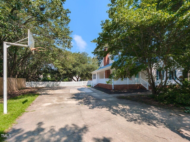 6020 Wildorlyn Cir, Raleigh, NC 27603 - view of side of property featuring a chimney, driveway, and covered porch