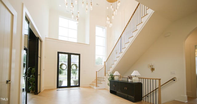 1620 Hunting Ridge Rd, Raleigh, NC 27615 - entrance foyer featuring a towering ceiling, arched walkways, healthy amount of natural light, stairs, and a chandelier