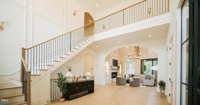 1620 Hunting Ridge Rd, Raleigh, NC 27615 - entrance foyer featuring a towering ceiling, arched walkways, a stone fireplace, stairway, and recessed lighting