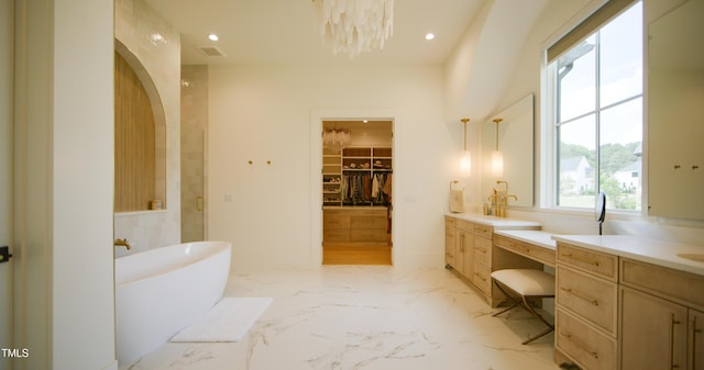 1620 Hunting Ridge Rd, Raleigh, NC 27615 - bathroom with vanity, a freestanding tub, a spacious closet, marble finish flooring, and recessed lighting