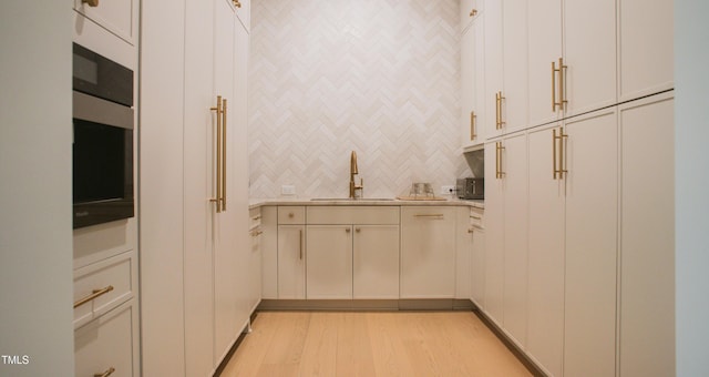 1620 Hunting Ridge Rd, Raleigh, NC 27615 - kitchen featuring light countertops, light wood finished floors, and backsplash