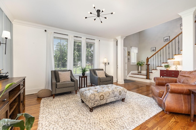 254 Charter Ct SE, Concord, NC 28025 - living area featuring wood finished floors, ornate columns, stairway, a chandelier, and crown molding