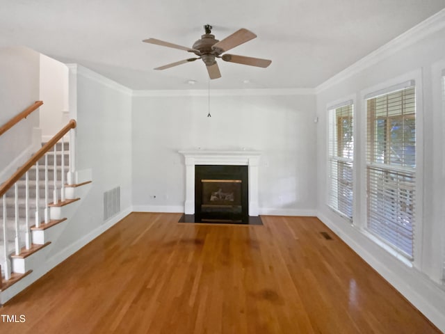 2408 Tiltonshire Ln, Apex, NC 27539 - unfurnished living room with wood finished floors, crown molding, a fireplace with flush hearth, a ceiling fan, and stairway
