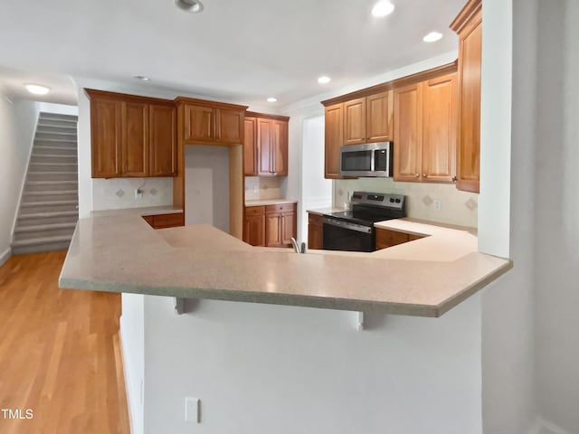 2408 Tiltonshire Ln, Apex, NC 27539 - kitchen featuring stainless steel appliances, decorative backsplash, recessed lighting, a peninsula, and a breakfast bar area